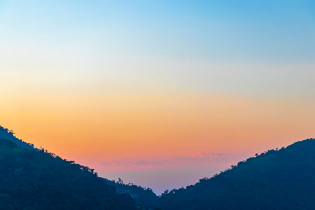 Beautiful golden colorful sunrise sunset behind the tropical mountain mountains hill hills.の写真素材