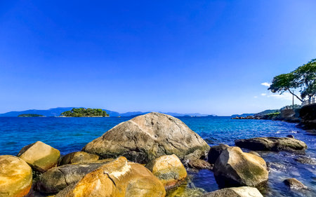 Panorama of tropical islands island nature coast beach with turquoise green and clear water rock rocks boulders boulder and blue sky in Angra dos Reis State of Rio de Janeiro Brazil.の写真素材