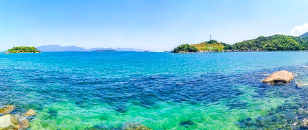 Panorama of tropical islands island nature coast beach with turquoise green and clear water rocks boulders and blue sky in Angra dos Reis State of Rio de Janeiro Brazil.の写真素材