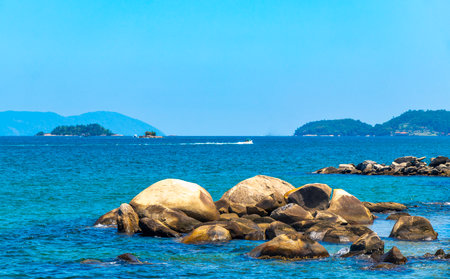 Panorama of tropical islands island nature coast beach with turquoise green and clear water rock rocks boulders boulder and blue sky in Angra dos Reis State of Rio de Janeiro Brazil.の写真素材