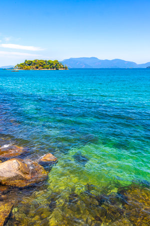 Panorama of tropical islands island nature coast beach with turquoise green and clear water rocks boulders and blue sky in Angra dos Reis State of Rio de Janeiro Brazil.の写真素材