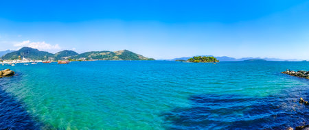 Panorama of tropical islands island nature coast beach with turquoise green and clear water rocks boulders and blue sky in Angra dos Reis State of Rio de Janeiro Brazil.の写真素材