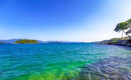 Panorama of tropical islands nature coast beach with turquoise green and clear water rocks boulders and blue sky in Angra dos Reis State of Rio de Janeiro Brazil.の写真素材