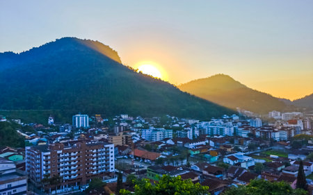 Beautiful golden colorful sunrise sunset behind the tropical mountain mountains hill hills with city town panorama view in Angra dos Reis State of Rio de Janeiro Brazil.の写真素材
