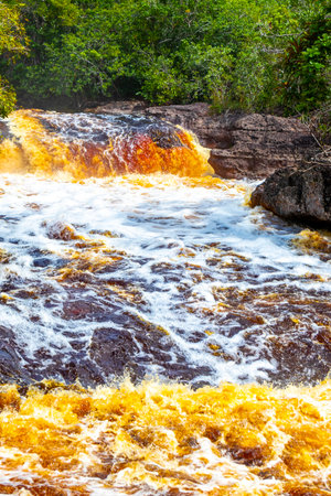 Red river water and waterfall Cachoeira Sucuriju orange yellow brown colors natural wonder in tropical jungle nature and rainforest in Presidente Figueiredo State of Amazonas Brazil.の写真素材