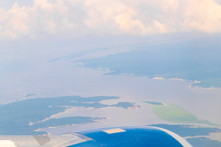 Flight in plane with aerial panorama view out of the window to Amazon river Rio negro tropical...