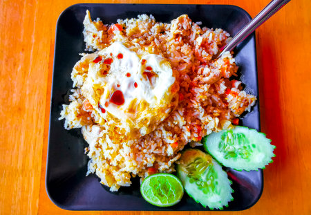 Thai food fried rice with chicken cucumber chili lime and egg on a plate in a restaurant in Patong Beach Kathu District Phuket Island Province Southern Thailand in Southeast Asia.の写真素材
