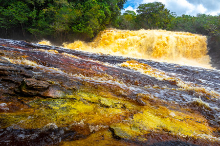 Red river water and waterfall Cachoeira Sucuriju orange yellow brown colors natural wonder in...