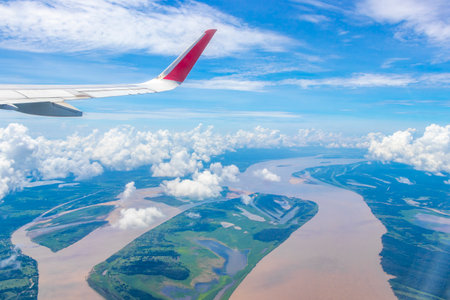 Flight in plane with aerial panorama view out of the window to Amazon river Rio negro tropical jungle rainforest airplane wing of State of Amazonas Brazil.の写真素材