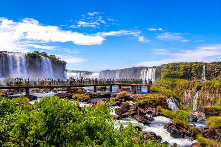 Foz do Iguacu Parana Brazil December 26, 2020 Iguazu Falls waterfall fall waterfalls cascades in tropical nature panorama with wooden trail people blue sky turquoise green water Brazil and Argentina.のeditorial素材