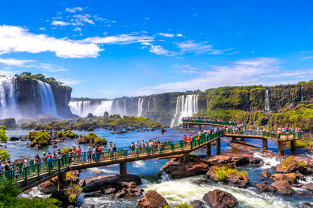 Foz do Iguacu Parana Brazil December 26, 2020 Iguazu Falls waterfall fall waterfalls cascades in tropical nature panorama with wooden trail people blue sky turquoise green water Brazil and Argentina.のeditorial素材
