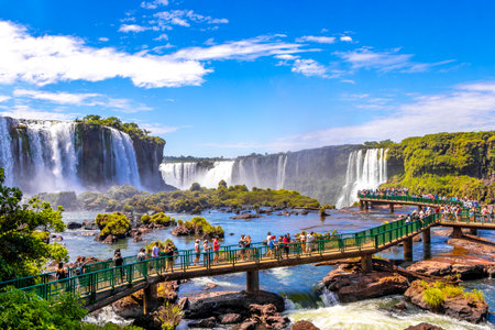 Foz do Iguacu Parana Brazil December 26, 2020 Iguazu Falls waterfall fall waterfalls cascades in tropical nature panorama with wooden trail people blue sky turquoise green water Brazil and Argentina.のeditorial素材