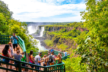 Foz do Iguacu Parana Brazil December 26, 2020 Iguazu Falls waterfall fall waterfalls cascades in tropical nature panorama with wooden trail people blue sky turquoise green water Brazil and Argentina.のeditorial素材