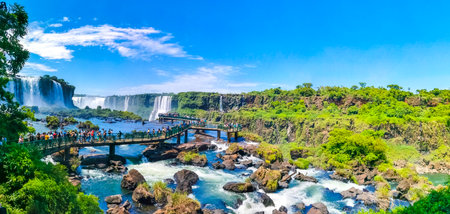 Foz do Iguacu Parana Brazil December 26, 2020 Iguazu Falls waterfall fall waterfalls cascades in tropical nature panorama with wooden trail people blue sky turquoise green water Brazil and Argentina.のeditorial素材