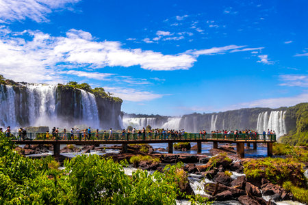 Foz do Iguacu Parana Brazil December 26, 2020 Iguazu Falls waterfall fall waterfalls cascades in tropical nature panorama with wooden trail people blue sky turquoise green water Brazil and Argentina.のeditorial素材