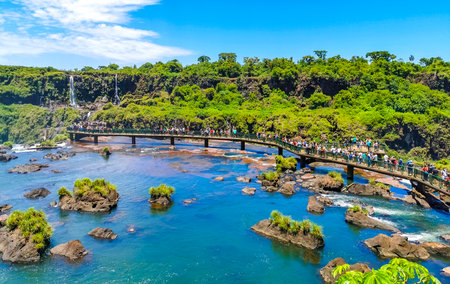 Foz do Iguacu Parana Brazil December 26, 2020 Iguazu Falls waterfall fall waterfalls cascades in tropical nature panorama with wooden trail people blue sky turquoise green water Brazil and Argentina.のeditorial素材