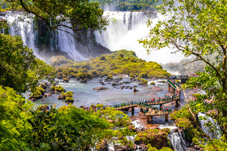 Foz do Iguacu Parana Brazil December 26, 2020 Iguazu Falls waterfall fall waterfalls cascades in tropical nature panorama with wooden trail people blue sky turquoise green water Brazil and Argentina.のeditorial素材