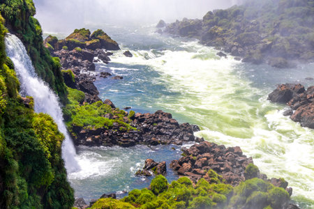 Foz do Iguacu Iguazu Falls waterfall fall waterfalls cascade cascades in tropical nature rainforest panorama view with blue sky and turquoise green water in Parana Brazil and Misiones Argentina.の写真素材