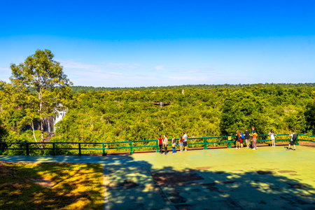 Foz do Iguacu Parana Brazil December 26, 2020 Iguazu Falls waterfall fall waterfalls cascades in tropical nature panorama with wooden trail people blue sky turquoise green water Brazil and Argentina.のeditorial素材