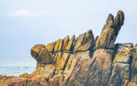 Rocky tropical landscape panorama view with turquoise blue clear water waves and rocks in Patong Beach Kathu District Phuket Island Province Southern Thailand in Southeast Asia.の写真素材