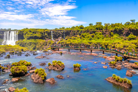 Foz do Iguacu Parana Brazil December 26, 2020 Iguazu Falls waterfall fall waterfalls cascades in tropical nature panorama with wooden trail people blue sky turquoise green water Brazil and Argentina.のeditorial素材