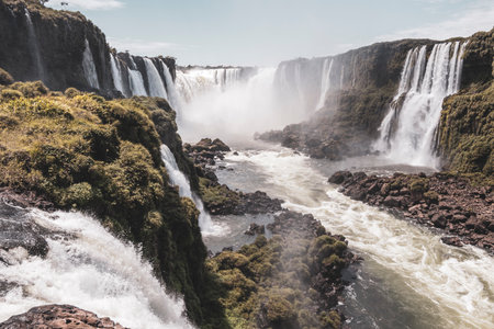 Foz do Iguacu Iguazu Falls waterfall fall waterfalls cascade cascades in tropical nature rainforest panorama view with blue sky and turquoise green water in Parana Brazil and Misiones Argentina.の写真素材