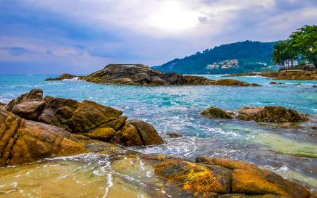 Amazing rocky Kalim Beach tropical landscape panorama view with blue sky turquoise water waves and rocks in Patong Beach Kathu District Phuket Island Province Southern Thailand in Southeast Asia.の写真素材