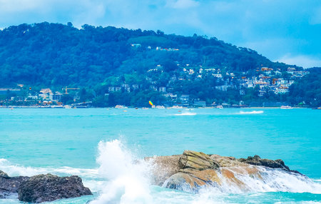 Amazing rocky Kalim Beach tropical landscape panorama view with blue sky turquoise water waves and rocks in Patong Beach Kathu District Phuket Island Province Southern Thailand in Southeast Asia.の写真素材