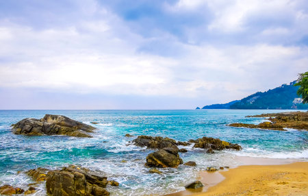 Amazing rocky Kalim Beach tropical landscape panorama view with blue sky turquoise water waves and rocks in Patong Beach Kathu District Phuket Island Province Southern Thailand in Southeast Asia.の写真素材