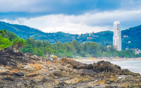 Amazing rocky Kalim Beach tropical landscape panorama view with blue sky turquoise water waves palm trees and rocks in Patong Beach Kathu Phuket Island Province Southern Thailand in Southeast Asia.の写真素材