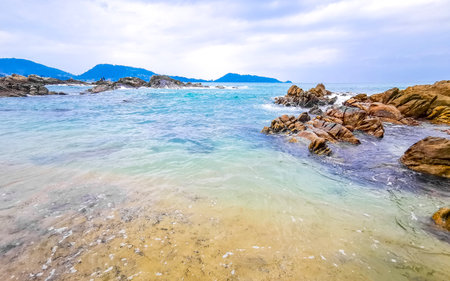 Amazing rocky Kalim Beach tropical landscape panorama view with blue sky turquoise water waves and rocks in Patong Beach Kathu District Phuket Island Province Southern Thailand in Southeast Asia.の写真素材