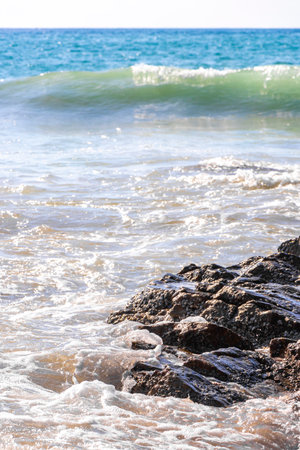 Rocky Kalim Beach tropical landscape panorama view with turquoise blue clear water waves sand and rocks in Patong Beach Kathu District Phuket Island Province Southern Thailand in Southeast Asia.の写真素材