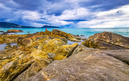 Amazing rocky Kalim Beach tropical landscape panorama view with blue sky turquoise water waves and rocks in Patong Beach Kathu District Phuket Island Province Southern Thailand in Southeast Asia.の写真素材