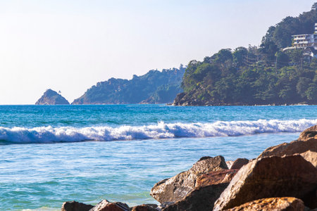Rocky Kalim Beach tropical landscape panorama view with turquoise blue clear water waves sand and rocks in Patong Beach Kathu District Phuket Island Province Southern Thailand in Southeast Asia.の写真素材