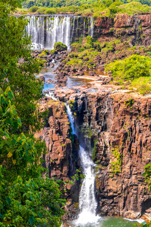 Foz do Iguacu Iguazu Falls waterfall fall waterfalls cascade cascades in tropical nature rainforest panorama view with blue sky and turquoise green water in Parana Brazil and Misiones Argentina.の写真素材