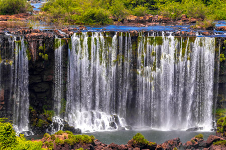 Foz do Iguacu Iguazu Falls waterfall fall waterfalls cascade cascades in tropical nature rainforest panorama view with blue sky and turquoise green water in Parana Brazil and Misiones Argentina.の写真素材