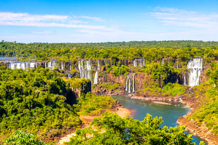 Foz do Iguacu Iguazu Falls waterfall fall waterfalls cascade cascades in tropical nature rainforest panorama view with blue sky and turquoise green water in Parana Brazil and Misiones Argentina.の写真素材