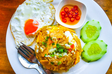Thai food fried rice with chicken cucumber chili lime and egg on a plate in a restaurant in Patong Beach Kathu District Phuket Island Province Southern Thailand in Southeast Asia.の写真素材