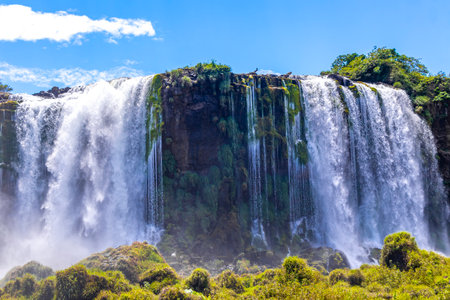 Foz do Iguacu Iguazu Falls waterfall fall waterfalls cascade cascades in tropical nature rainforest panorama view with blue sky and turquoise green water in Parana Brazil and Misiones Argentina.の写真素材