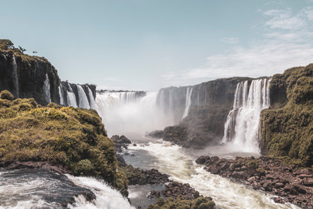 Foz do Iguacu Iguazu Falls waterfall fall waterfalls cascade cascades in tropical nature rainforest panorama view with blue sky and turquoise green water in Parana Brazil and Misiones Argentina.の写真素材