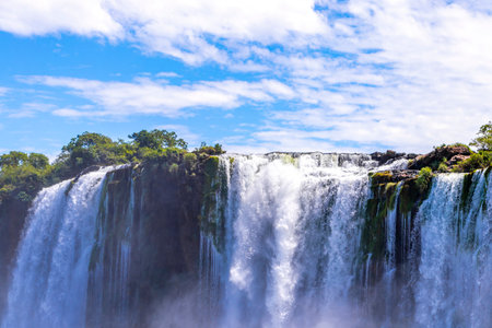 Foz do Iguacu Iguazu Falls waterfall fall waterfalls cascade cascades in tropical nature rainforest panorama view with blue sky and turquoise green water in Parana Brazil and Misiones Argentina.の写真素材