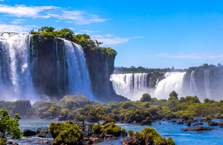 Foz do Iguacu Iguazu Falls waterfall fall waterfalls cascade cascades in tropical nature rainforest panorama view with blue sky and turquoise green water in Parana Brazil and Misiones Argentina.の写真素材
