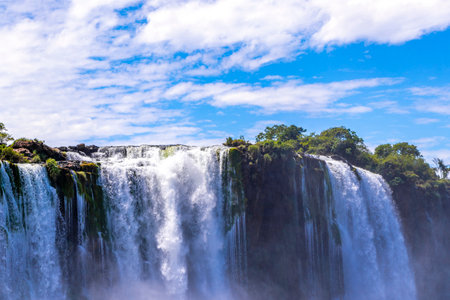 Foz do Iguacu Iguazu Falls waterfall fall waterfalls cascade cascades in tropical nature rainforest panorama view with blue sky and turquoise green water in Parana Brazil and Misiones Argentina.の写真素材