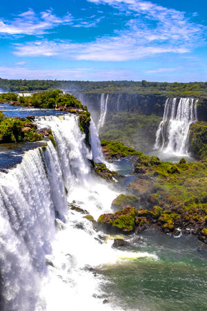 Foz do Iguacu Iguazu Falls waterfall fall waterfalls cascade cascades in tropical nature rainforest panorama view with blue sky and turquoise green water in Parana Brazil and Misiones Argentina.の写真素材
