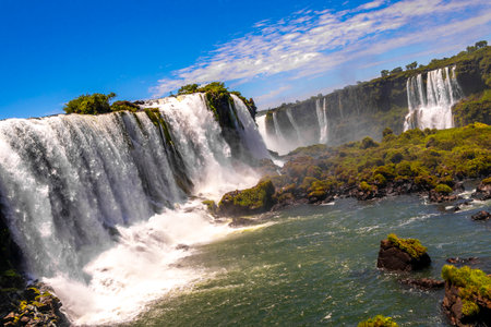Foz do Iguacu Iguazu Falls waterfall fall waterfalls cascade cascades in tropical nature rainforest panorama view with blue sky and turquoise green water in Parana Brazil and Misiones Argentina.の写真素材