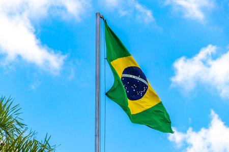 Brazilian flag waving in the wind with blue sky in the background.の写真素材