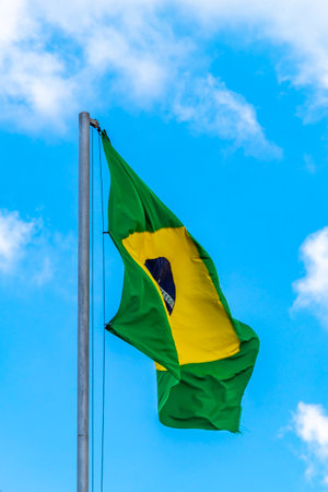 Brazilian flag waving in the wind with blue sky in the background.の写真素材