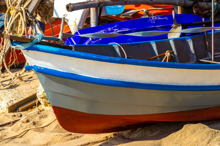 Fisher boat boats on the beach sand with sand and turquoise blue water.