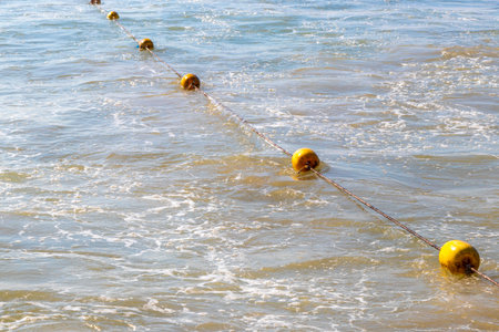 Beautiful blue and turquoise water waves ocean and yellow red orange buoy and ropes in the water in Patong Beach Kathu District Phuket Island Province Southern Thailand in Southeast Asia.の写真素材