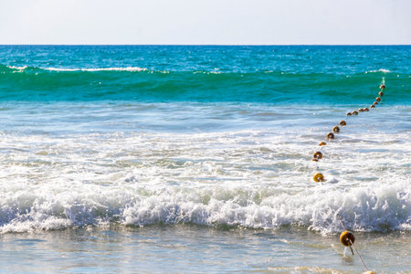 Beautiful blue and turquoise water waves ocean and yellow red orange buoy and ropes in the water in Patong Beach Kathu District Phuket Island Province Southern Thailand in Southeast Asia.の写真素材